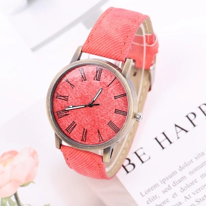Detail of coral pink denim watch face and bronze casing with Roman numeral markers