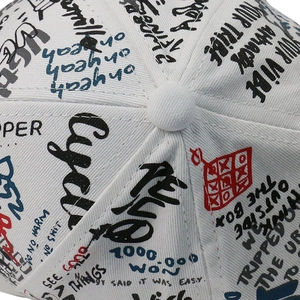 Gros plan d'une casquette blanche avec imprimés graffiti urbains et coutures précises
