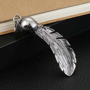 Retro stainless steel skull and feather pendant with gothic textures on dark background