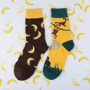 Detail of funny mid-calf cotton socks with yellow banana and monkey patterns