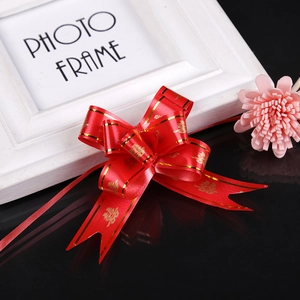 Detail of red ribbon bow with gold Double Happiness print on black reflective surface