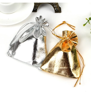 Detail view of gold and silver drawstring gift bags with metallic fabric texture