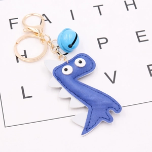 Close-up of blue PU leather dinosaur keychain with golden ring and small blue bell