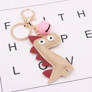Beige PU leather dinosaur keychain with pink bell and gold metal lobster clasp for bags