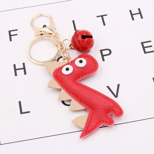 Detailed view of a red PU leather dinosaur keychain with a gold bell and metal hardware