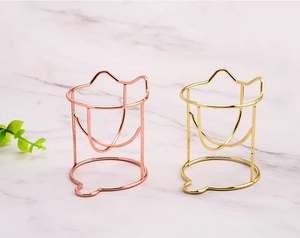 Detailed view of rose gold and gold metal cat-shaped beauty blender storage racks