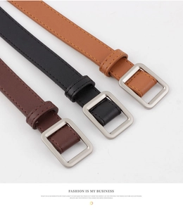 Close-up of minimalist skinny leather belts in brown and black with square matte buckles