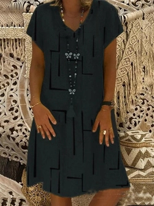 Close-up of black V-neck short sleeve dress with geometric patterns and texture