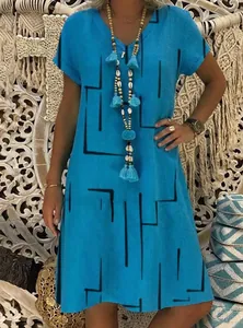Close-up of bright blue V-neck dress with black geometric lines and tassel necklace