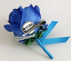 Detail of blue faux rose boutonniere featuring a dual-use metal clip and safety pin back
