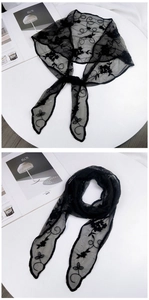 Macro detail of black lace embroidered scarf with floral pattern on hexagonal mesh fabric