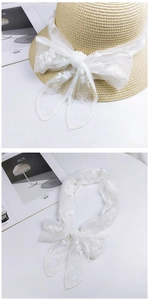 Close-up of white lace embroidery ribbon used as a decorative hat band or hair scarf