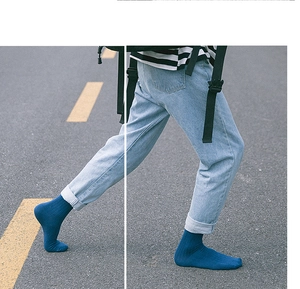 Street view of navy blue crew socks styled with light denim jeans for a casual urban look