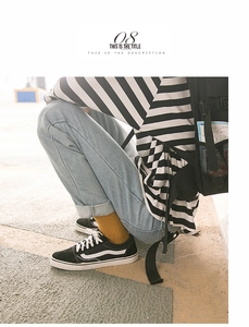 Close-up of ginger yellow crew socks paired with classic black canvas shoes and jeans
