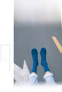 Detailed view of dark blue ribbed cotton socks worn on a paved road background