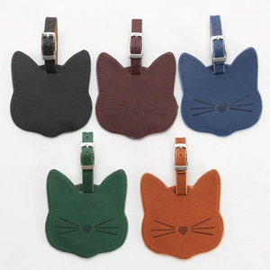 Close-up of cat-shaped leather luggage tags in five colors with metal buckle straps