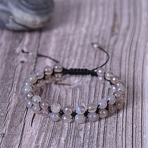 Close-up of double-layer faceted Indian agate beads woven with black cord on wood