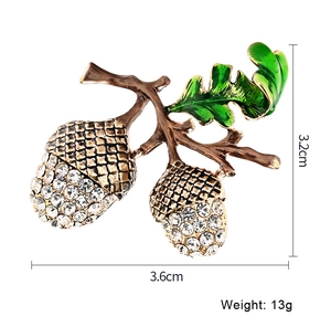 Detailed view of hazelnut brooch with sparkling rhinestones and green enamel leaf detail