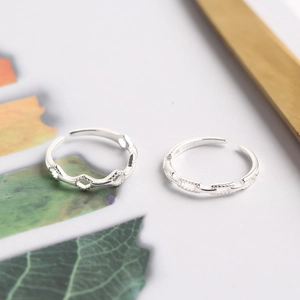 Set of two S925 sterling silver open rings with minimalist chain texture on green leaf background