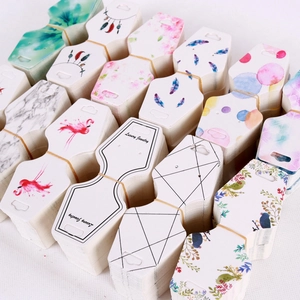 Macro view of various earring display card designs including floral and marble patterns