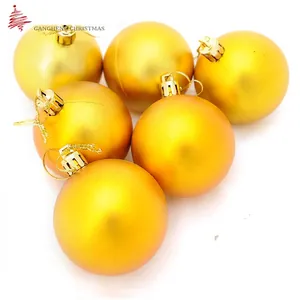 Set of six matte gold Christmas balls with gold hanging cords on a white background