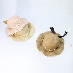 Detail of kids straw hats with wavy brims, pearl chains and elegant ribbon ties