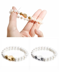 Detail showing elastic transparent cord on a pearl bracelet with heart charms