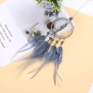 Detailed view of grey handmade dreamcatcher with soft feathers and silver bead accents