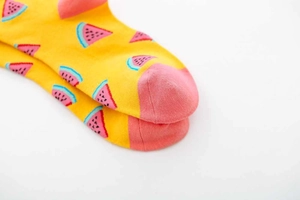 Detail of yellow cotton socks featuring pink watermelon patterns and contrast toe