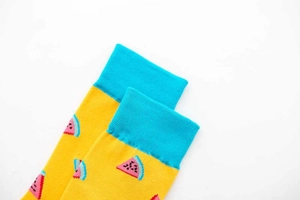 Close-up of yellow cotton socks featuring blue cuffs and a pink watermelon pattern