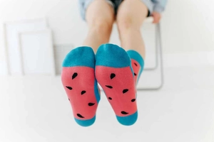 Detailed view of pink mid-calf socks with vibrant watermelon pattern and blue accents
