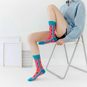 Pink mid-calf cotton socks with watermelon pattern and blue trim shown on a model
