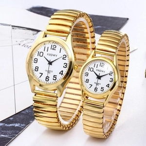Macro view of gold quartz couple watches with elastic bands and clear numeric dials