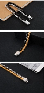 Detailed macro view of multi-layered titanium steel chain bracelets in black, silver, and gold