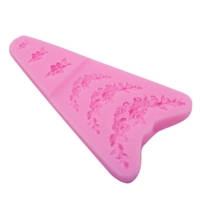 Gros plan sur un moule en silicone rose avec des motifs de fleurs et de feuilles