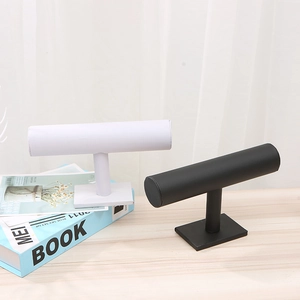 Black and white T-bar velvet jewelry stands for bracelets and watches on a wooden table