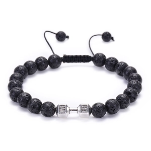 Detail of black lava stone beads with a silver dumbbell charm on an adjustable bracelet