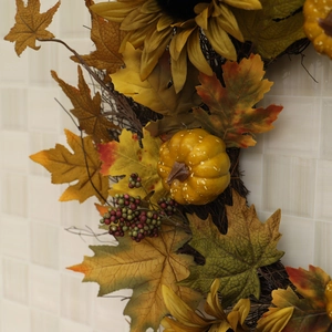 Autumn wreath with green pumpkins, sunflowers and maple leaves for Thanksgiving decor