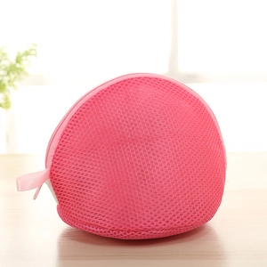 Detail of rose red thick mesh laundry bag for delicate bras on a wooden surface