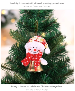 Detail of plush snowman ornament with plaid hat and golden bell on Christmas tree branch