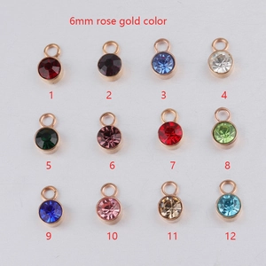 Set of 12 rose gold birthstone pendants with 6mm faceted round gemstones on white back