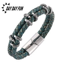 Detail of blue and brown braided leather bracelet with eagle claw metal charms and magnetic clasp