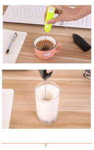 Macro detail of electric handheld frother mixing coffee and milk in a glass cup