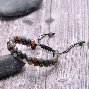 Macro shot of multi-colored natural agate faceted beads on a black braided cord bracelet