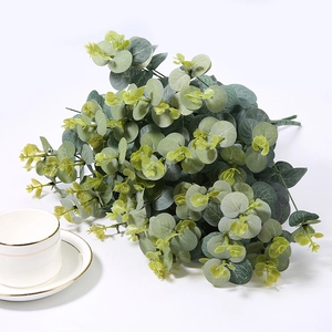 Close-up of artificial eucalyptus leaves with realistic grey-green texture and ceramic cup