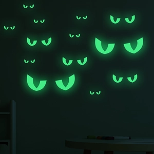 Close-up of green glowing eye stickers for Halloween wall decoration in the dark