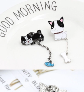 Detail of enamel pet brooches with cat fish and dog bone charms on metallic backings