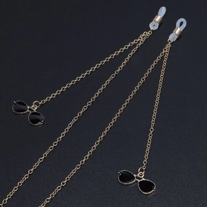 Chic gold-plated glasses chain featuring stylish black sunglasses charms on a dark texture