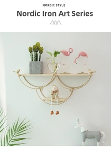 Close-up of golden iron wall shelf with wooden board and decorative bird element