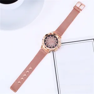 Détail d'une montre en maille or rose avec cadran floral ajouré et cristaux étincelants